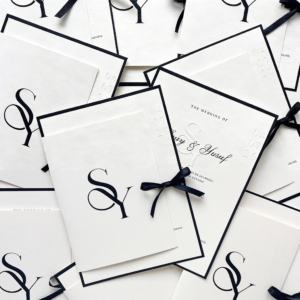 Custom wedding invitation with classic wording "The Wedding Of" and elegant space for bride and groom names, featuring "S" and "IRINZE" as placeholder text, showcasing professional wedding stationery design